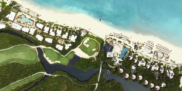 Toma aérea del campo de golf El Camaleón Mayakoba mostrando el diseño entre manglares y playa en Playa del Carmen, México.